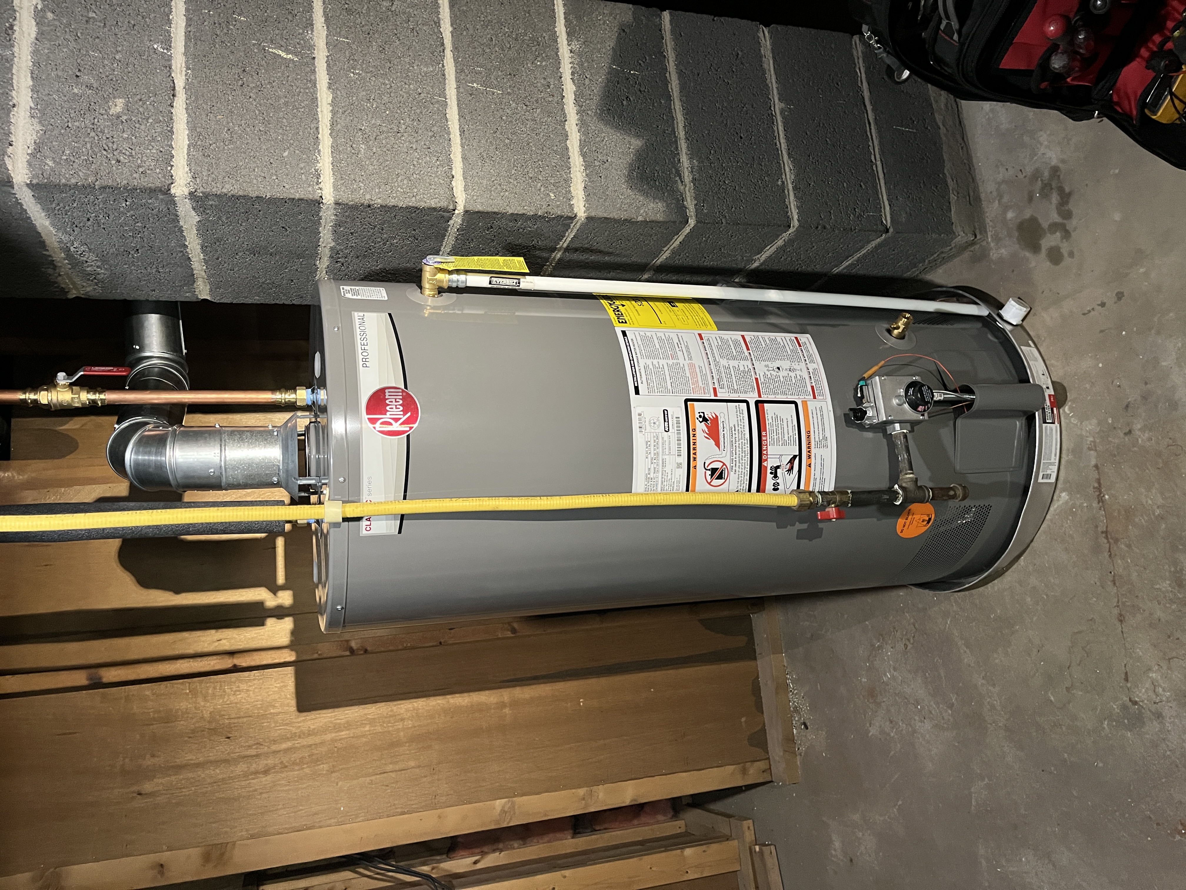 A newly installed Rheem 40 gallon atmospheric natural draft water heater in a Jenison basement, matching the review from Laura Burke.